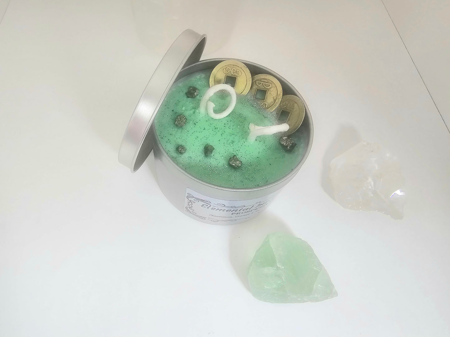 Green candle in a container with a decorative element on a white background
